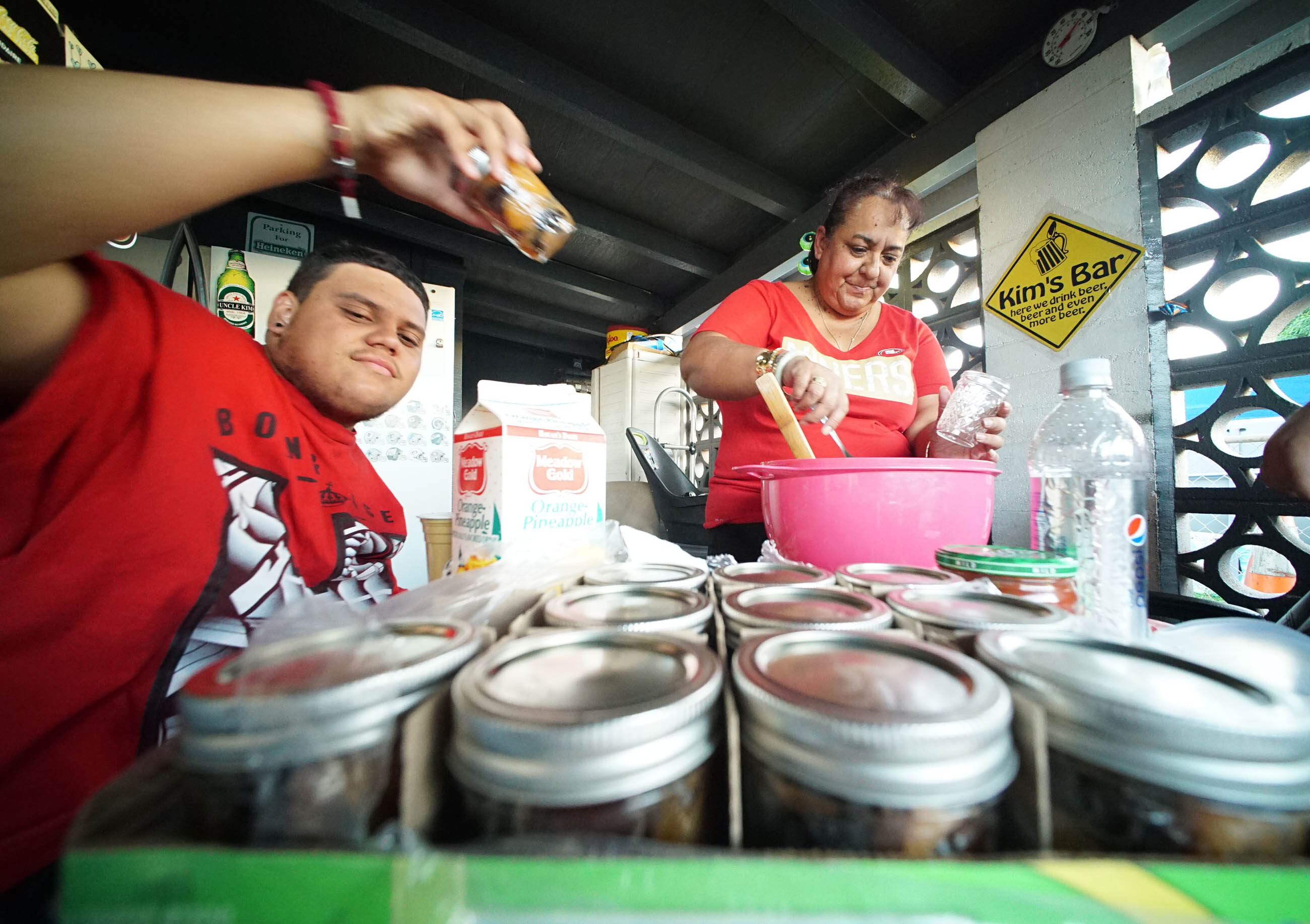 Annette Kanaulu with her son Imaikalani Kanaulu packing some jars of prune mui to give to a neighbor.